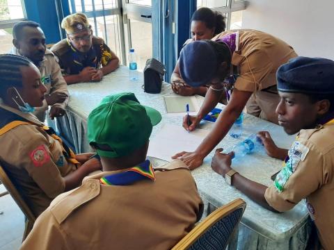 Scouts in Ethiopia gather around a table to discuss gender equality