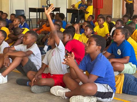 a group of scouts in a workshop, one is raising his hand