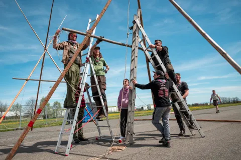 A group of Scouts build a wooden structure.