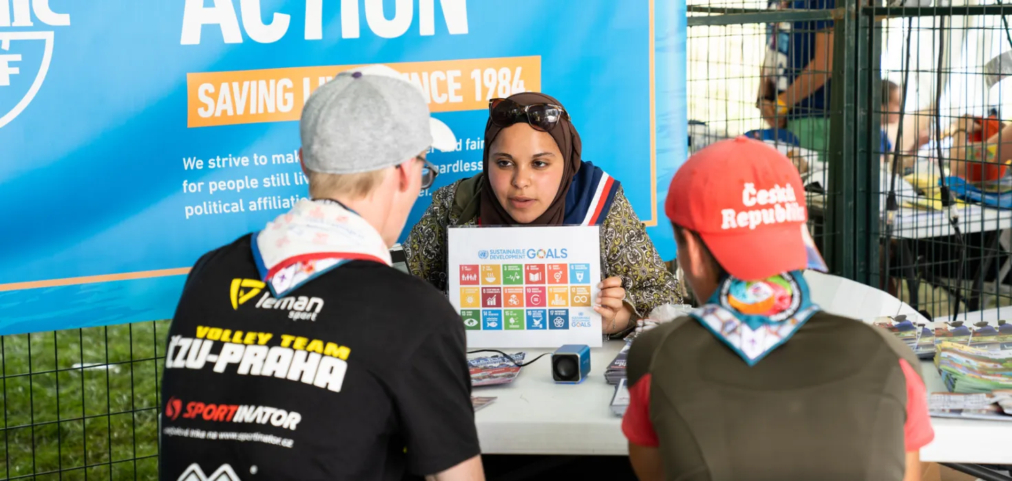 امرأة تعرض أهداف التنمية المستدامة للكشافة في قرية التنمية العالمية للمخيم الكشفي العالمي 2019، بأمريكا الشمالية.