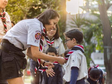 Un chef remettant un foulard à un Scout