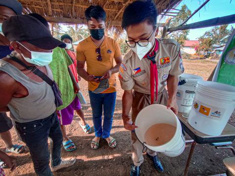 Raymund Romeo Guzman showing a bucket full of dirty water