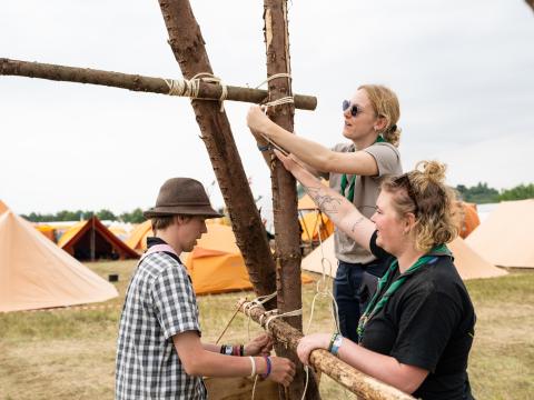 3 scouts au Jamboree National du Danemark travaillent ensemble pour assembler une table