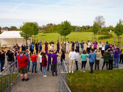 People wearing Scout scarves stand in a circle.