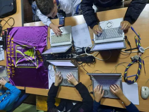 Serbian Scouts type on laptops on a table during JOTA-JOTI
