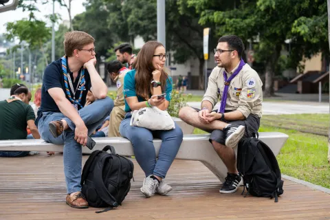Three Scouts talk on a bench outside during a forum on non-formal education in Brazil