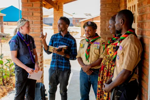 Scouts at a refugee camp in Malawi chat with staff from World Scouting
